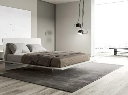 Letto liscio ed essenziale dove base e testiera si intersecano definendo una struttura minimal Plana di Presotto